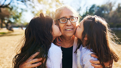 Two grand daughters kissing their grandmother's cheek
