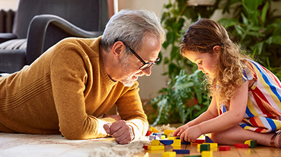 grandfather playing blocks with granddaughter