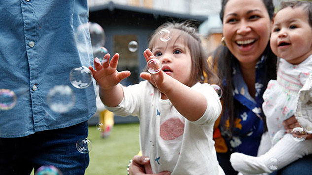 young daughter chasing bubbles