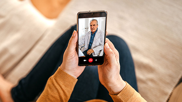 Person holding phone on a video call with their doctor