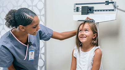 A nurse measuring the height of a child on a scale