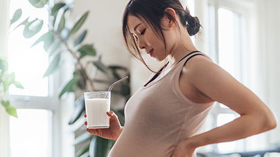 pregnant woman drinking a glass of milk