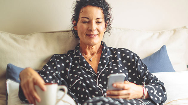 woman feeling under the weather looking at her phone