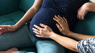 Doula's hands on woman's pregnant belly